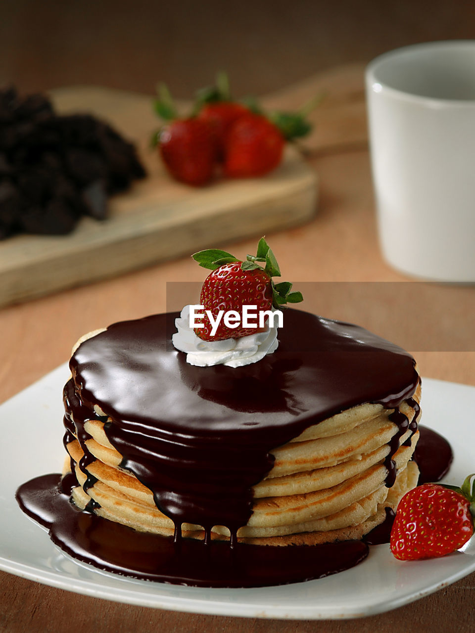 Close-up of melted chocolate on stacked pancakes at table