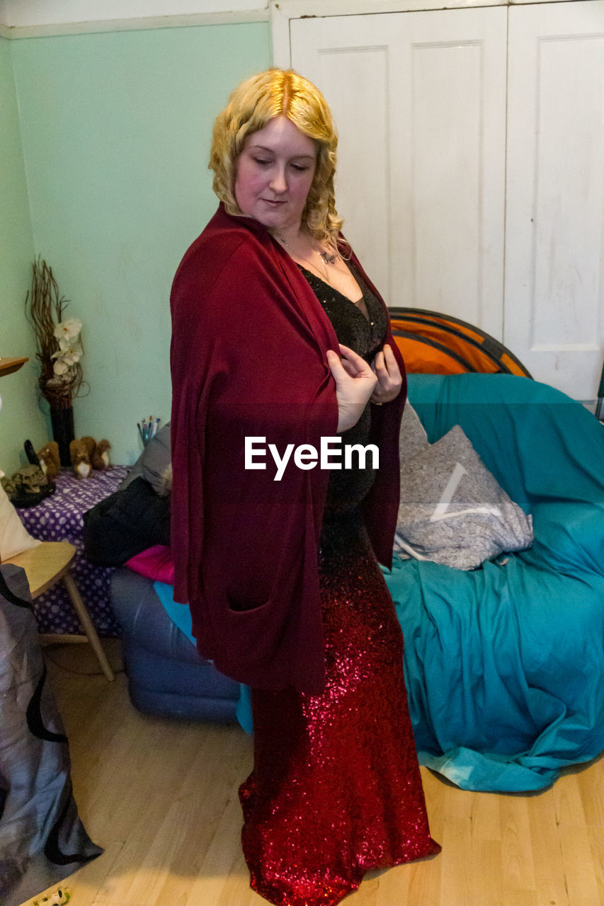 WOMAN WEARING HAT WHILE STANDING AT HOME