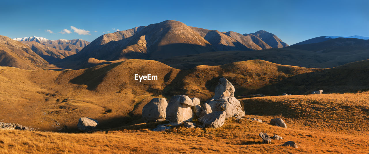 PANORAMIC SHOT OF ROCKS AND MOUNTAINS AGAINST SKY