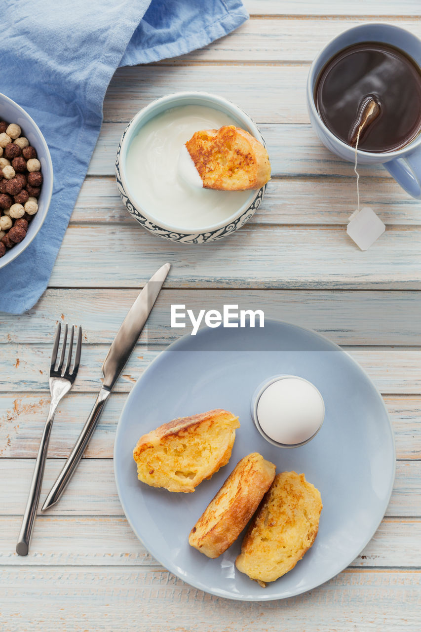 French fried toast with tea, boiled eggs and fresh yogurt. tasty farmer breakfast. flat lay