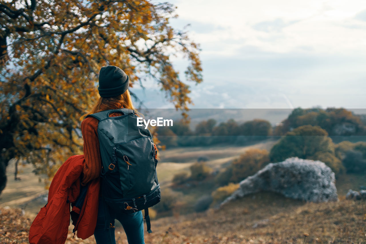 REAR VIEW OF MAN LOOKING AT VIEW OF TREES