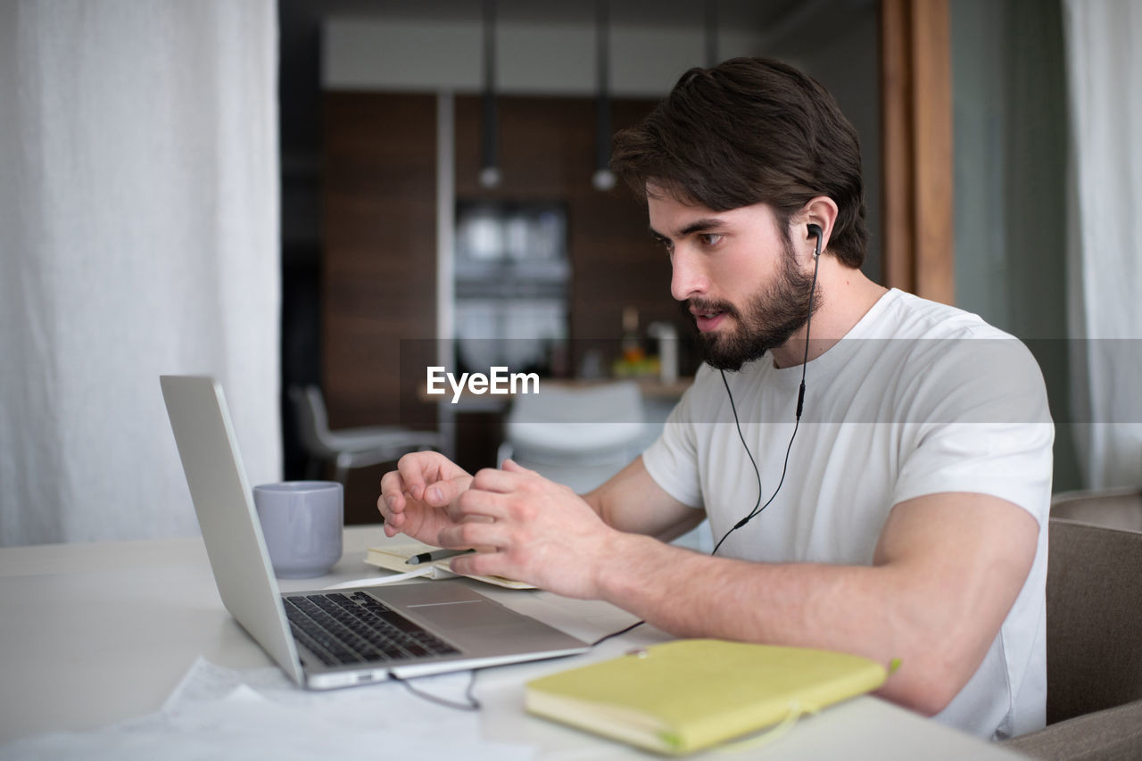 Bearded man making video call to colleagues