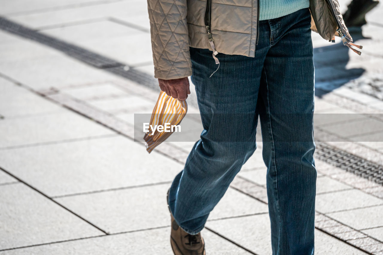 Low section of man walking on footpath