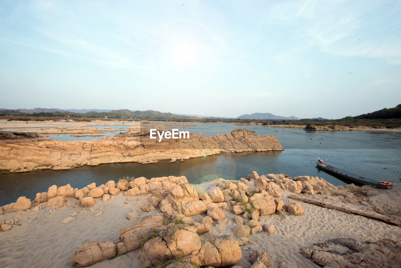 SCENIC VIEW OF ROCKS ON BEACH AGAINST SKY