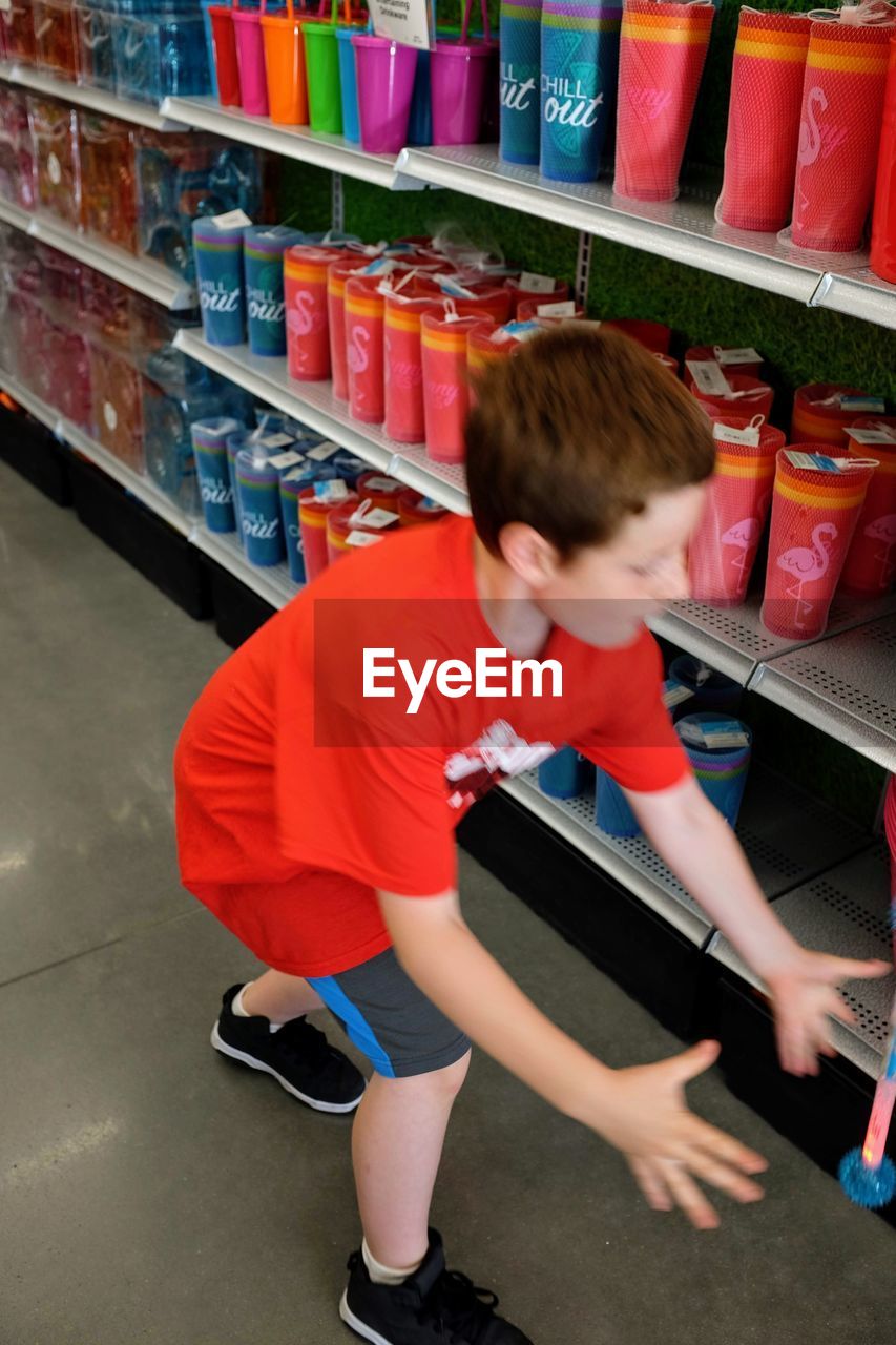 REAR VIEW OF BOY ON STORE