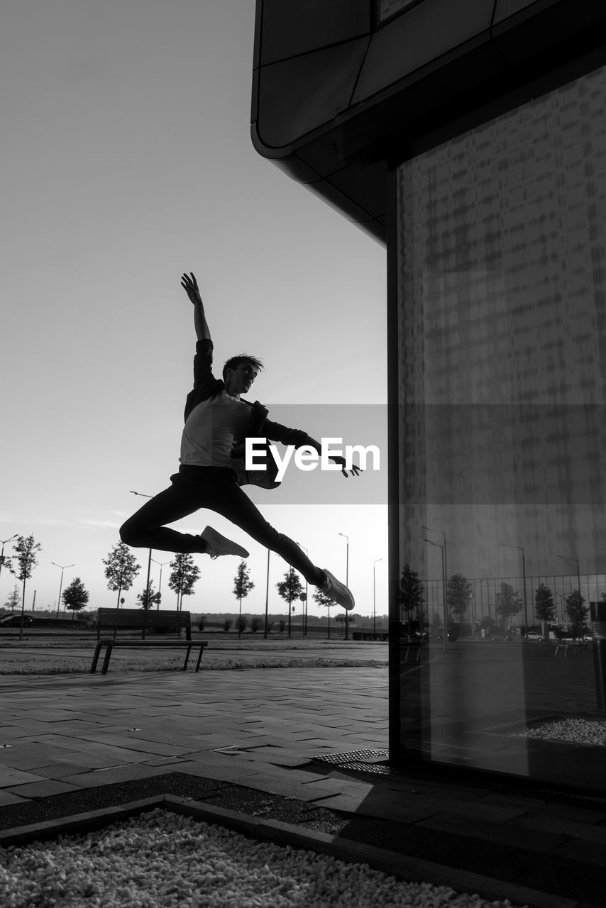 low angle view of man jumping in city