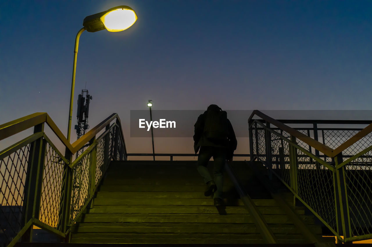 People on footbridge against sky