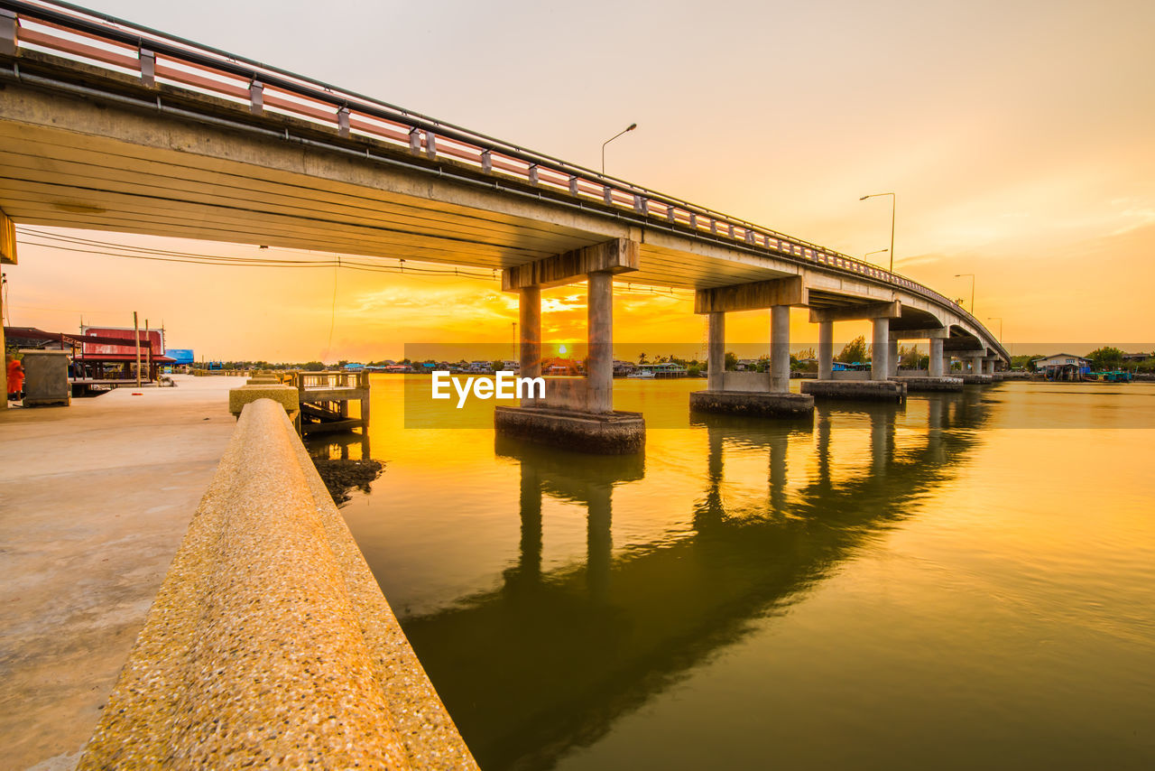 Bridge over river against sky during sunset