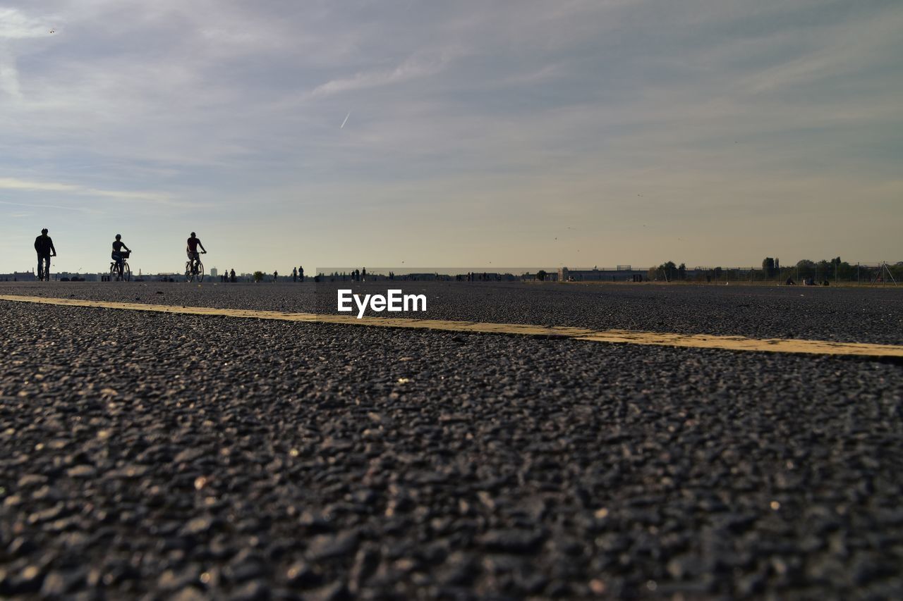 PEOPLE WALKING ON ROAD AGAINST SKY