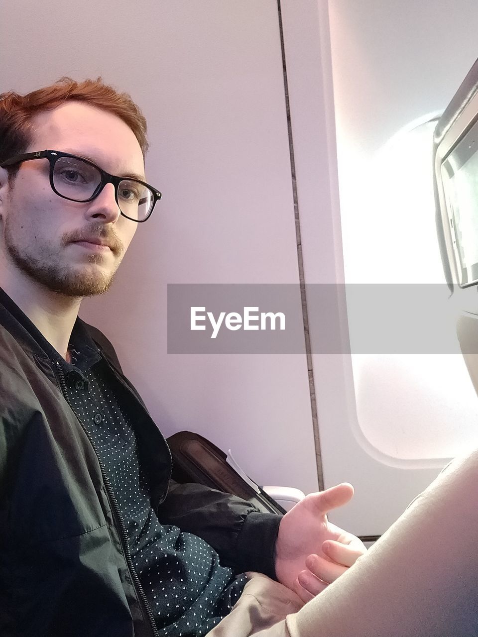 Portrait of young man sitting in airplane