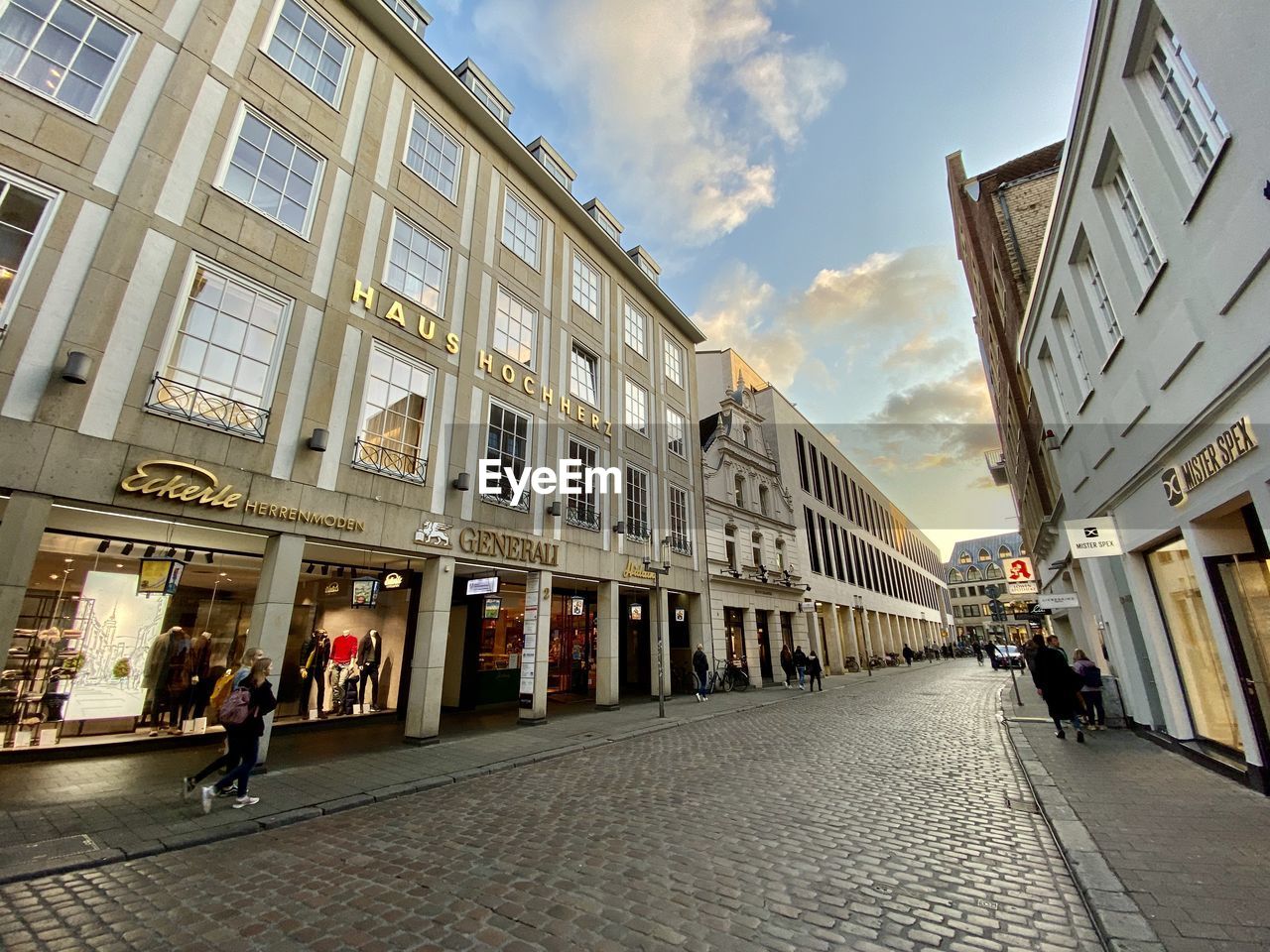 PEOPLE WALKING ON STREET AMIDST BUILDINGS IN CITY