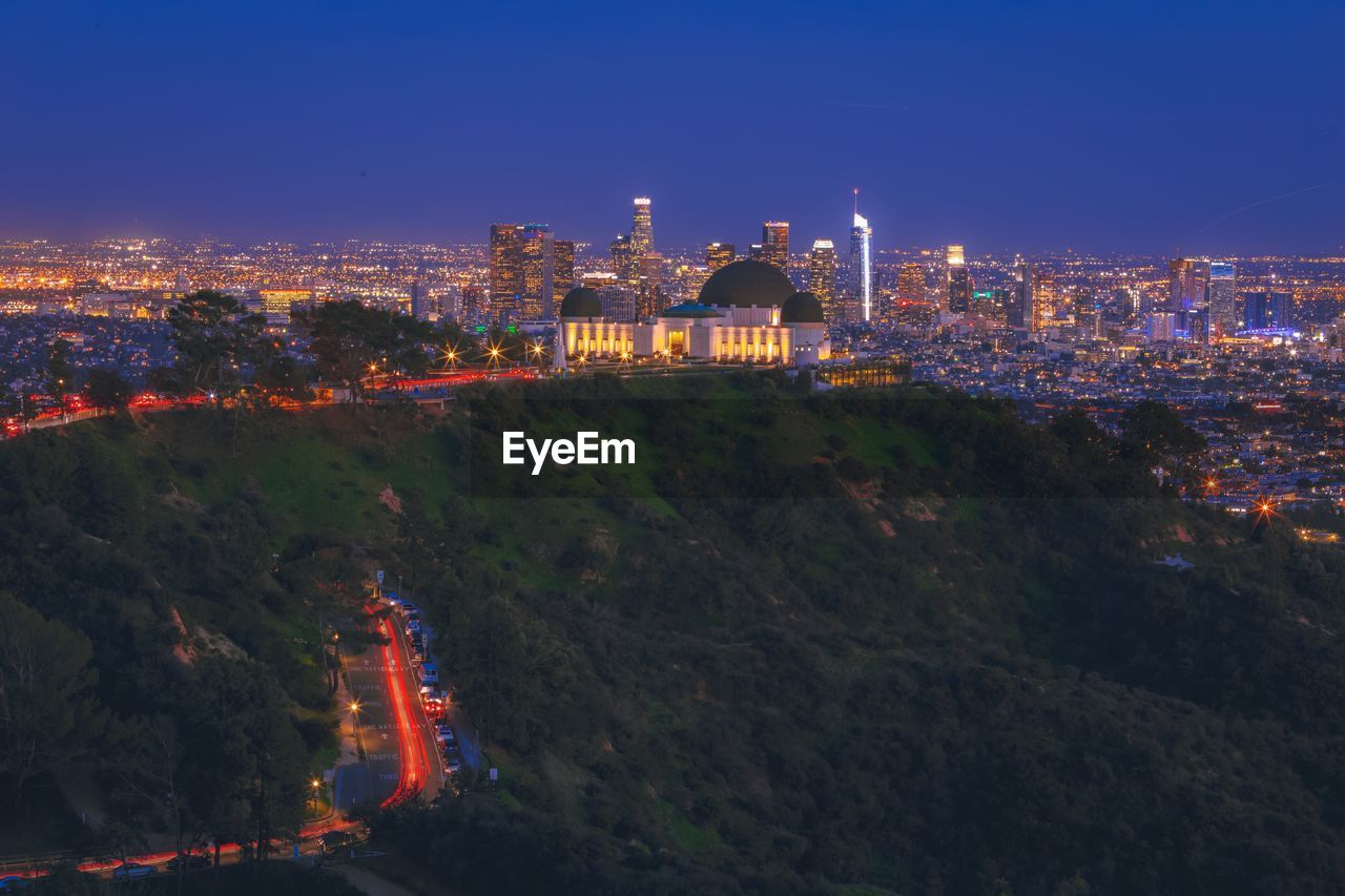 ILLUMINATED CITYSCAPE AGAINST SKY