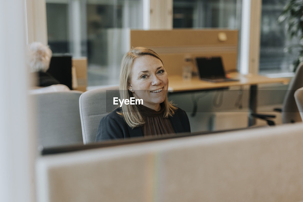 Smiling woman in office looking at camera