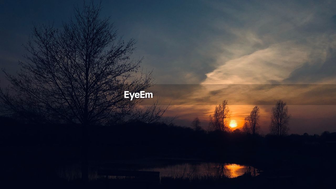 SILHOUETTE TREE BY LAKE AGAINST SKY DURING SUNSET