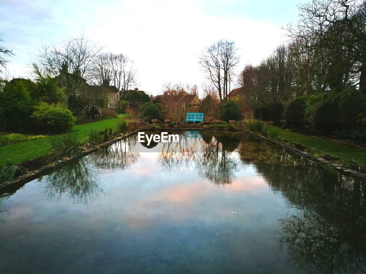 REFLECTION OF TREES AND WATER IN SKY