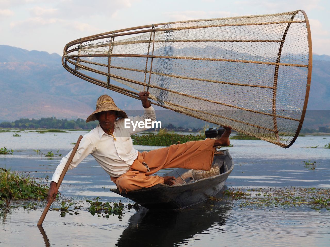 MAN HOLDING BOAT AGAINST SEA