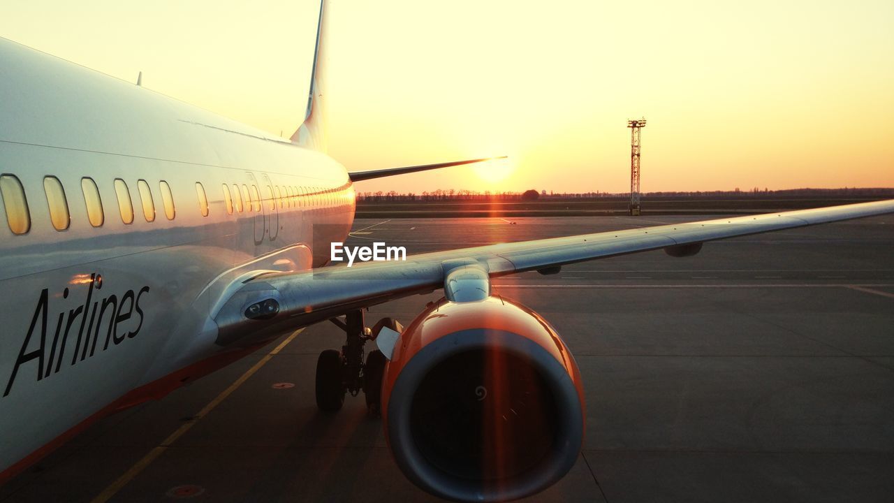 AIRPLANE AT AIRPORT RUNWAY AGAINST SKY