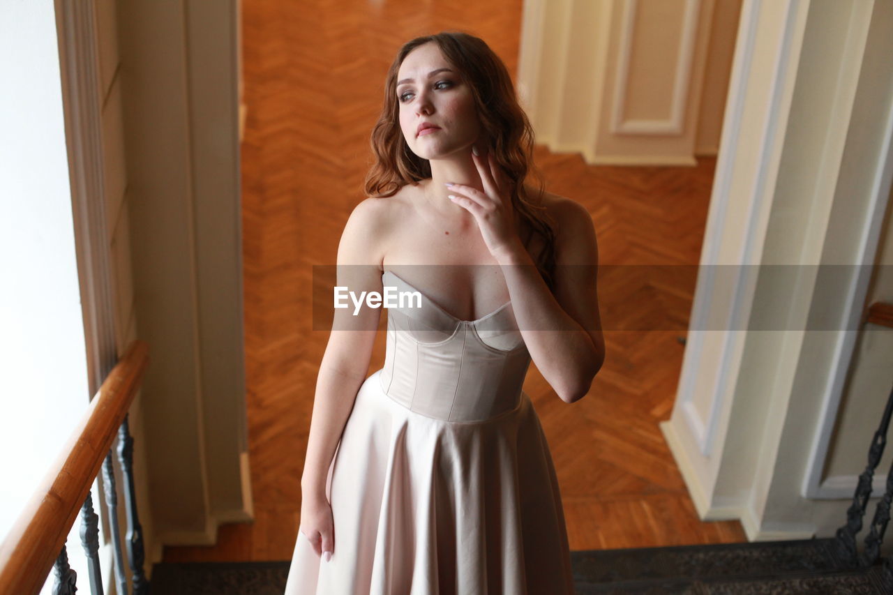 High angle view of beautiful woman wearing dress while standing on staircase