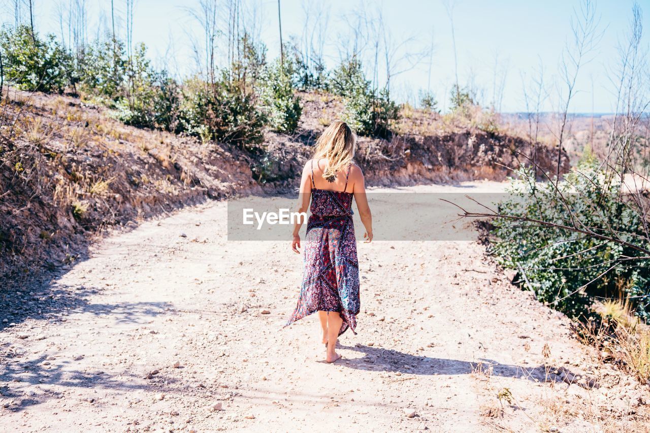 Rear view of woman walking at beach