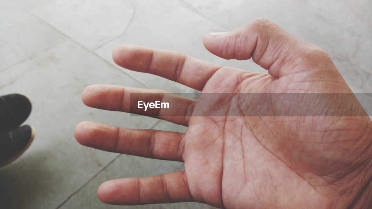 Cropped hand of man over floor