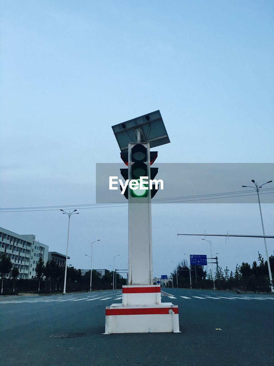 Illuminated traffic light on street against sky