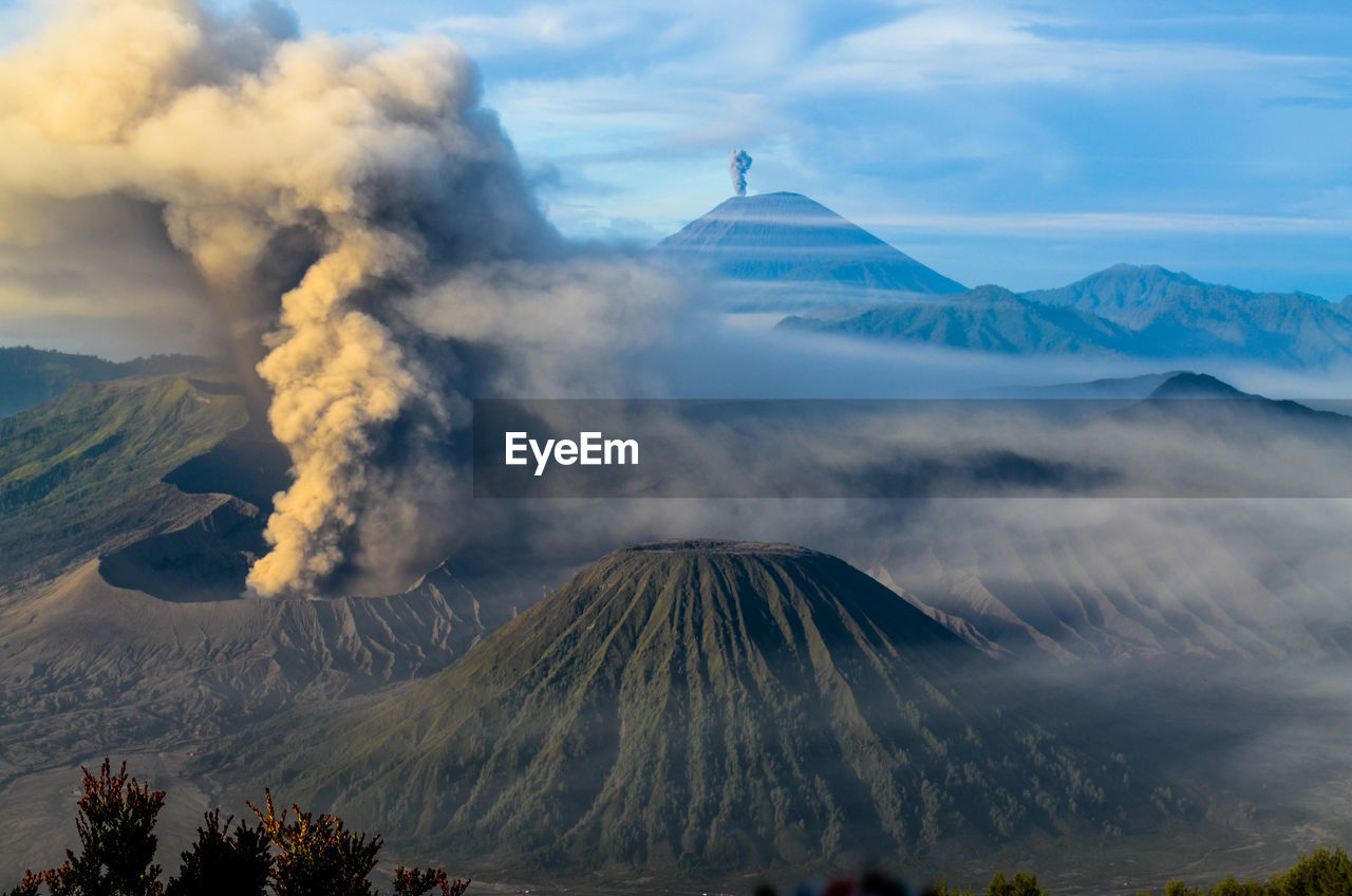 Smoke emitting from volcanic mountain against sky