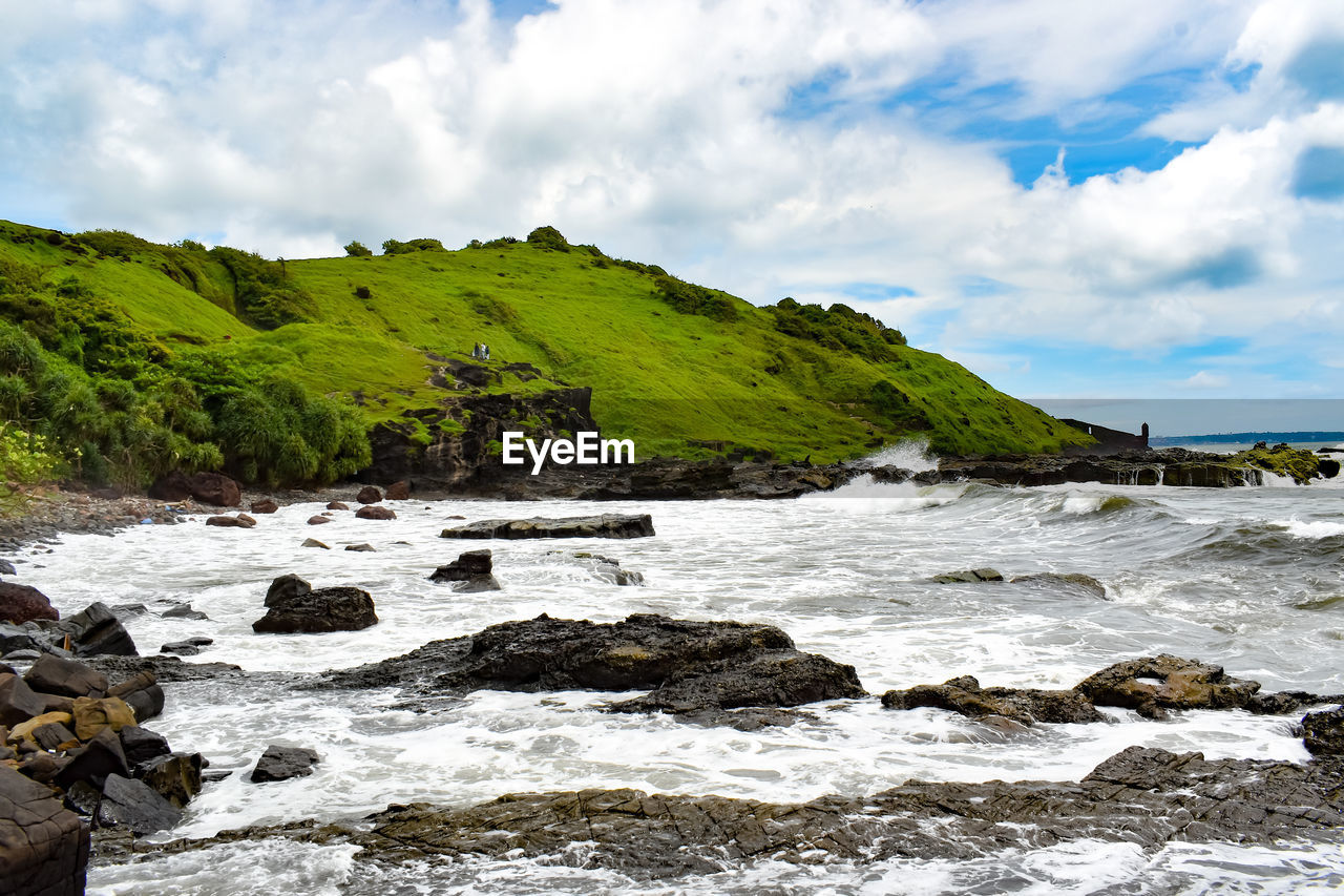 Scenic view of rocks in sea against sky