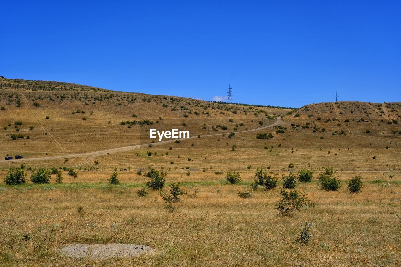 Scenic view of desert against clear blue sky