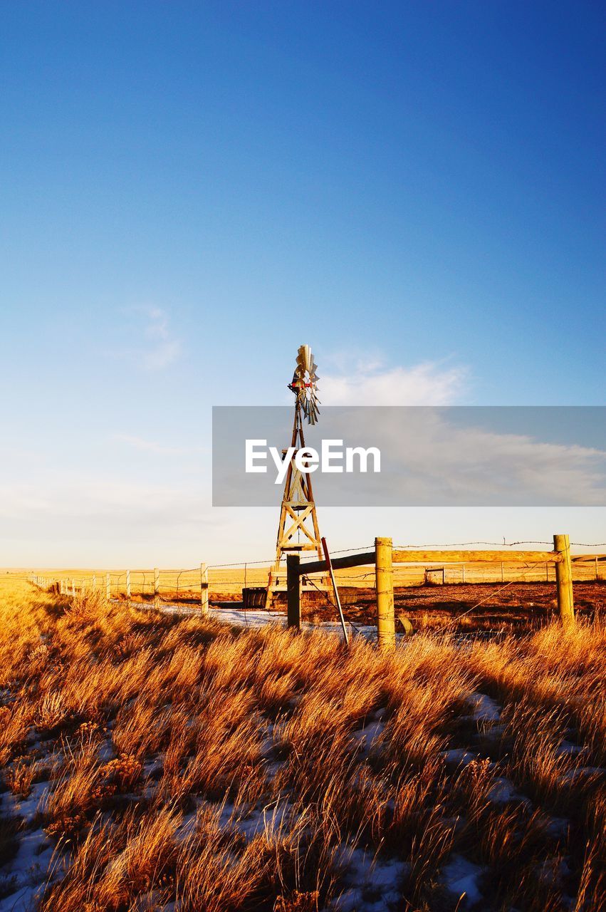 WINDMILL ON FIELD AGAINST SKY