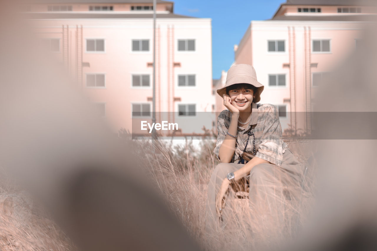 Full length of smiling young woman wearing hat