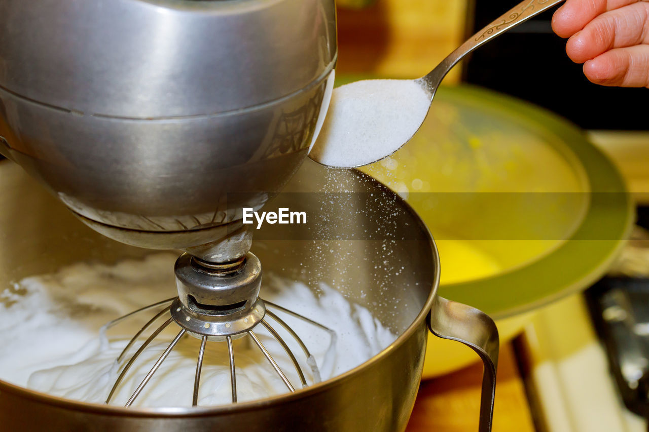 CLOSE-UP OF HAND POURING TEA IN GLASS