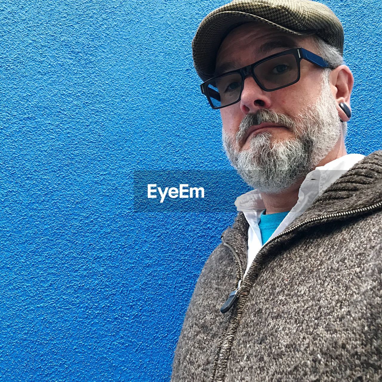 PORTRAIT OF MAN WEARING SUNGLASSES AGAINST BLUE SKY