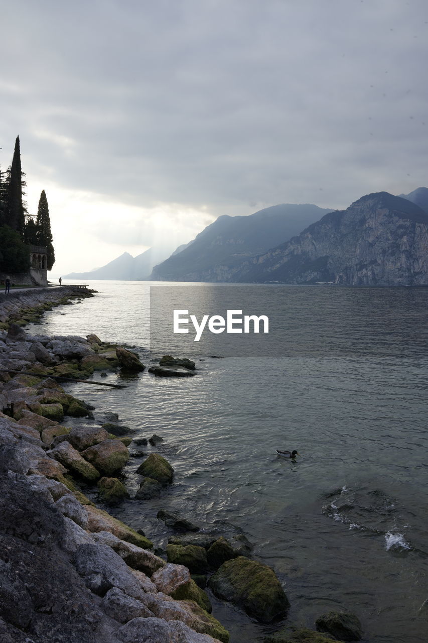 SCENIC VIEW OF SEA AGAINST MOUNTAINS