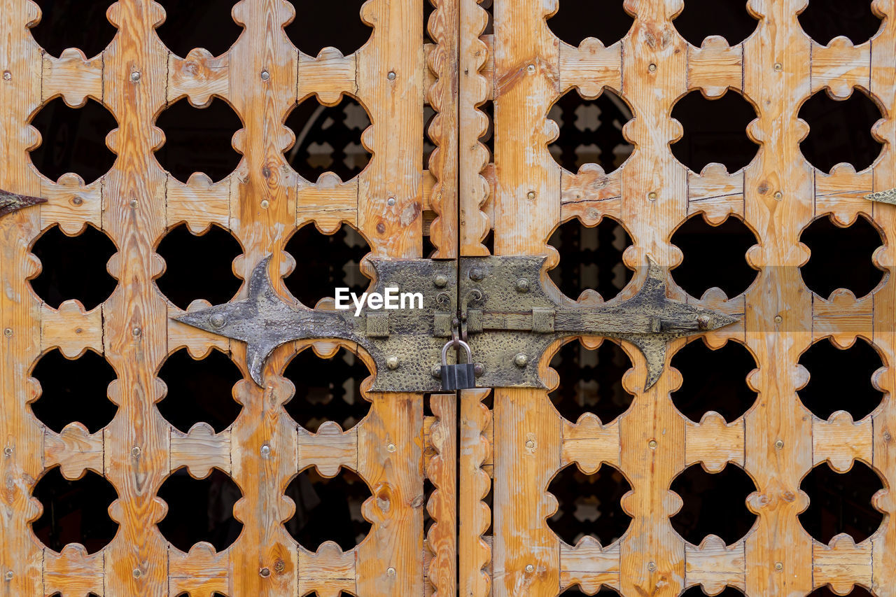 Close up locked carved wooden gate