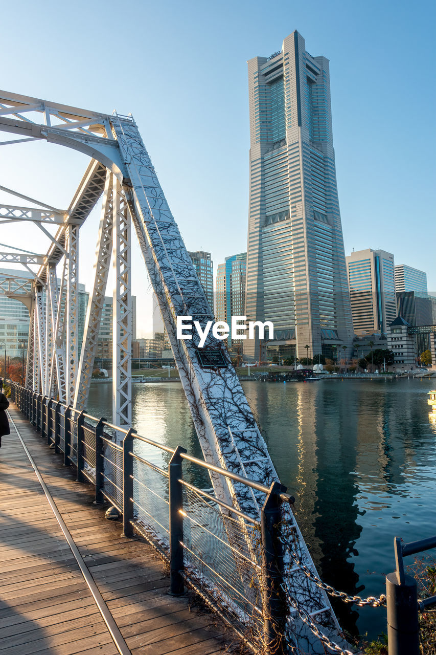 bridge over river in city against sky