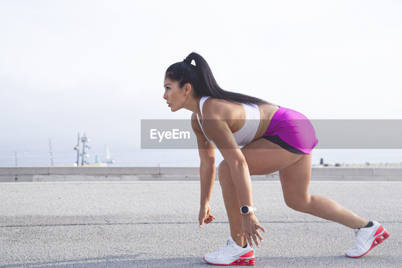 Sporty woman dressed in sportswear ready to start jogging in the city person