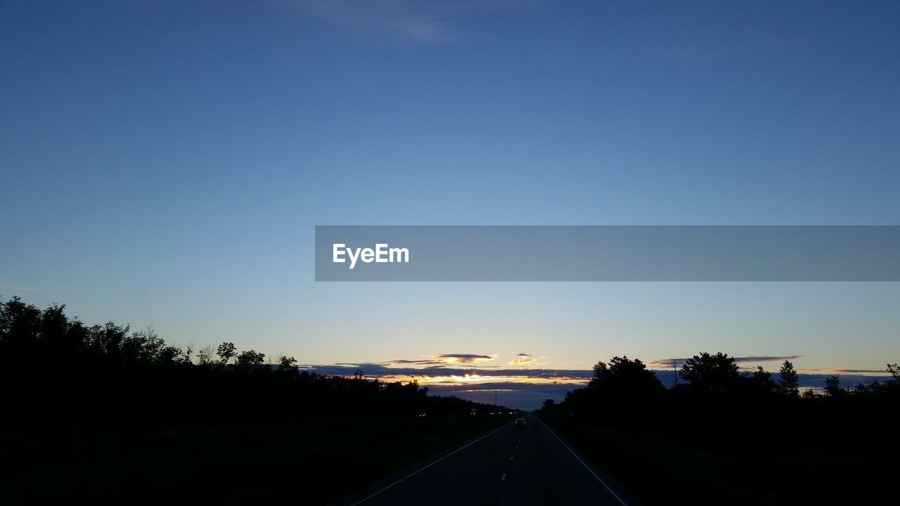 ROAD AGAINST CLEAR SKY AT SUNSET
