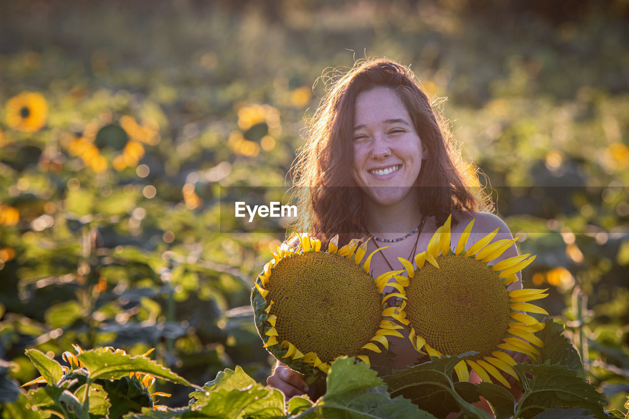 Portrait of smiling woman in sunflower farm