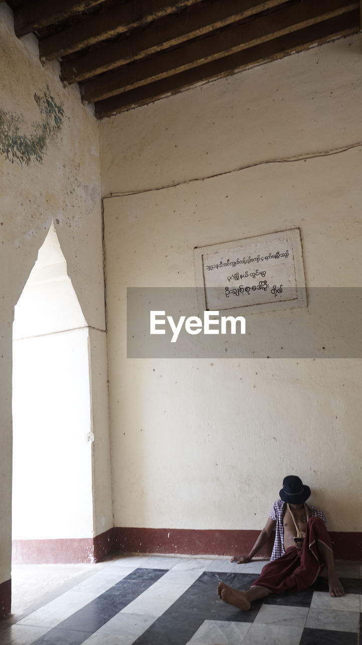 MAN WITH TEXT ON WALL IN BUILDING