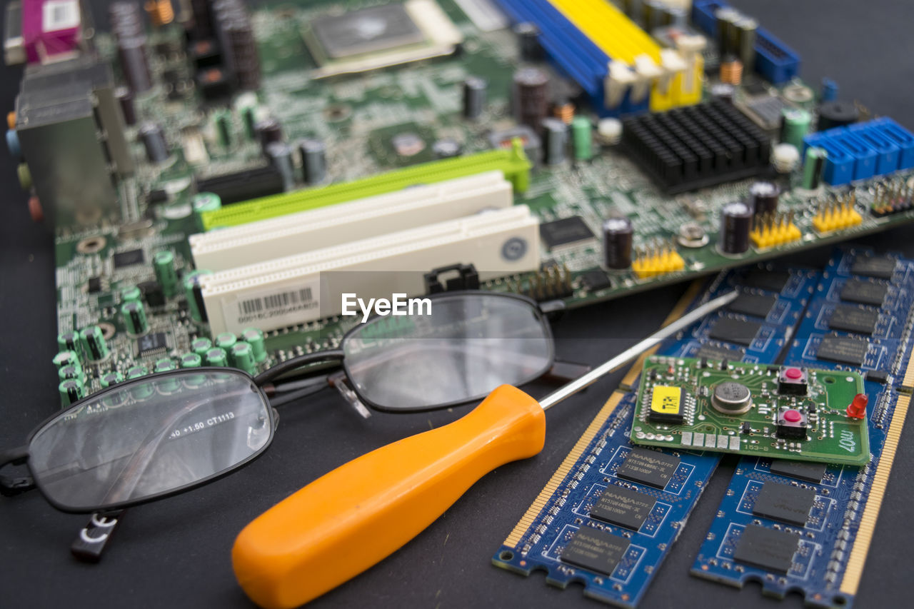 High angle view of circuit board with eyeglasses and pen on table