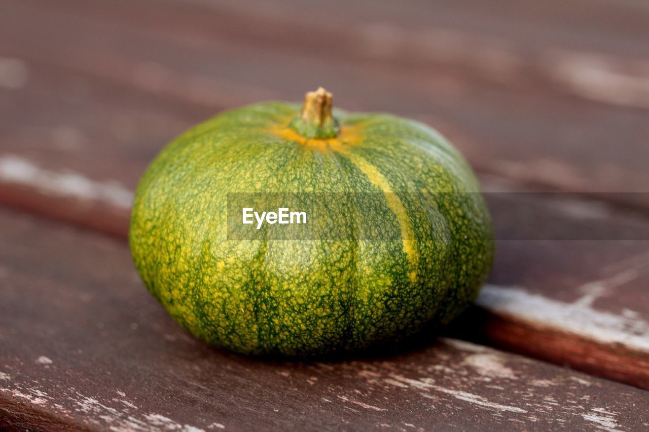 HIGH ANGLE VIEW OF PUMPKIN ON WOODEN TABLE