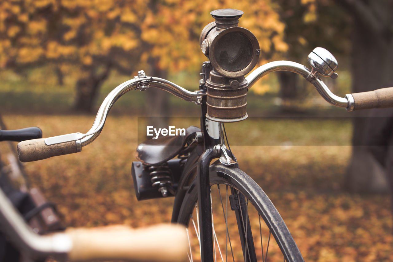 A penny-farthing bicycle with an old headlight in a park