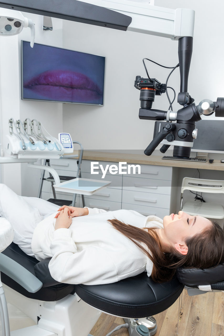 Female patient laying in dental chair befor treating