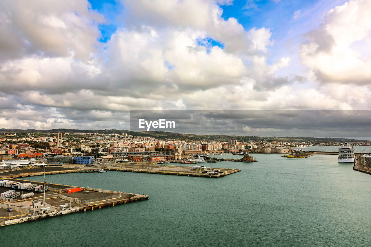 high angle view of city by sea against sky