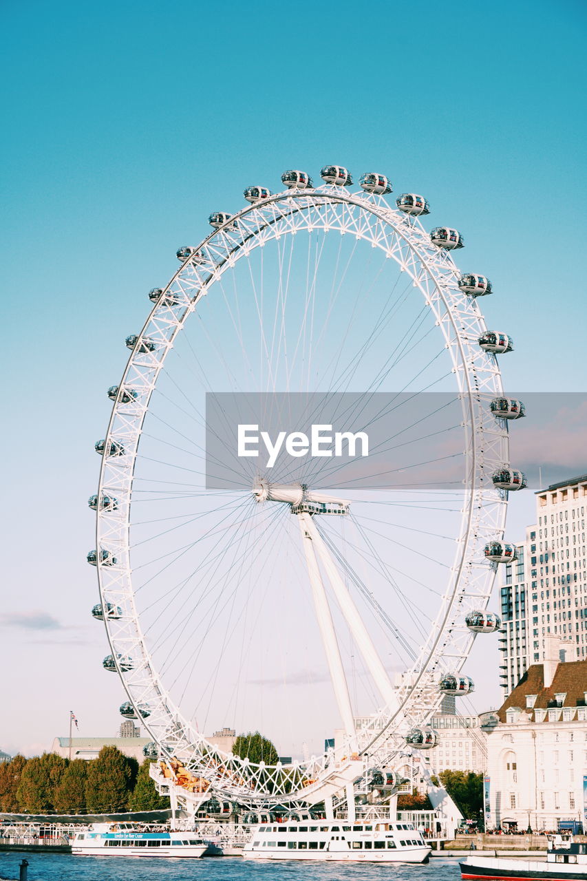 FERRIS WHEEL IN CITY AGAINST SKY