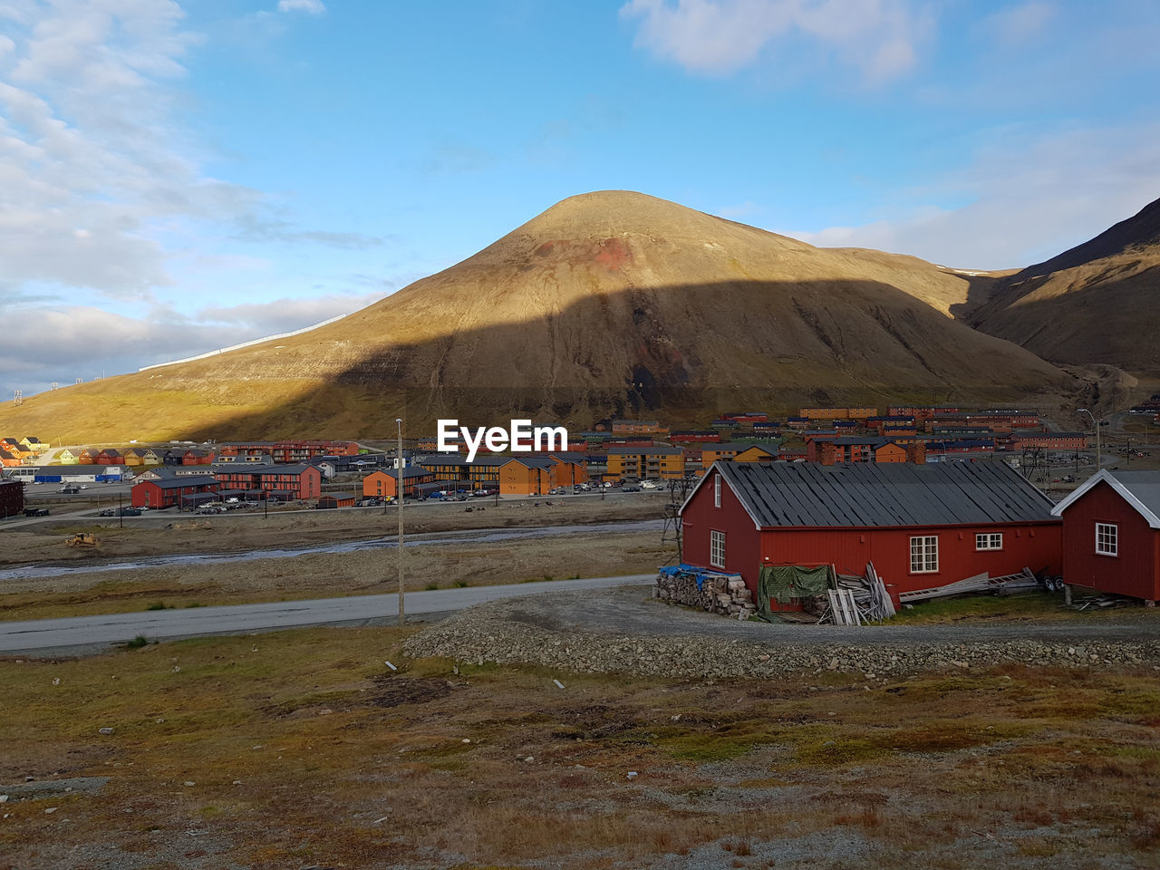 Built structure on land by mountain against sky