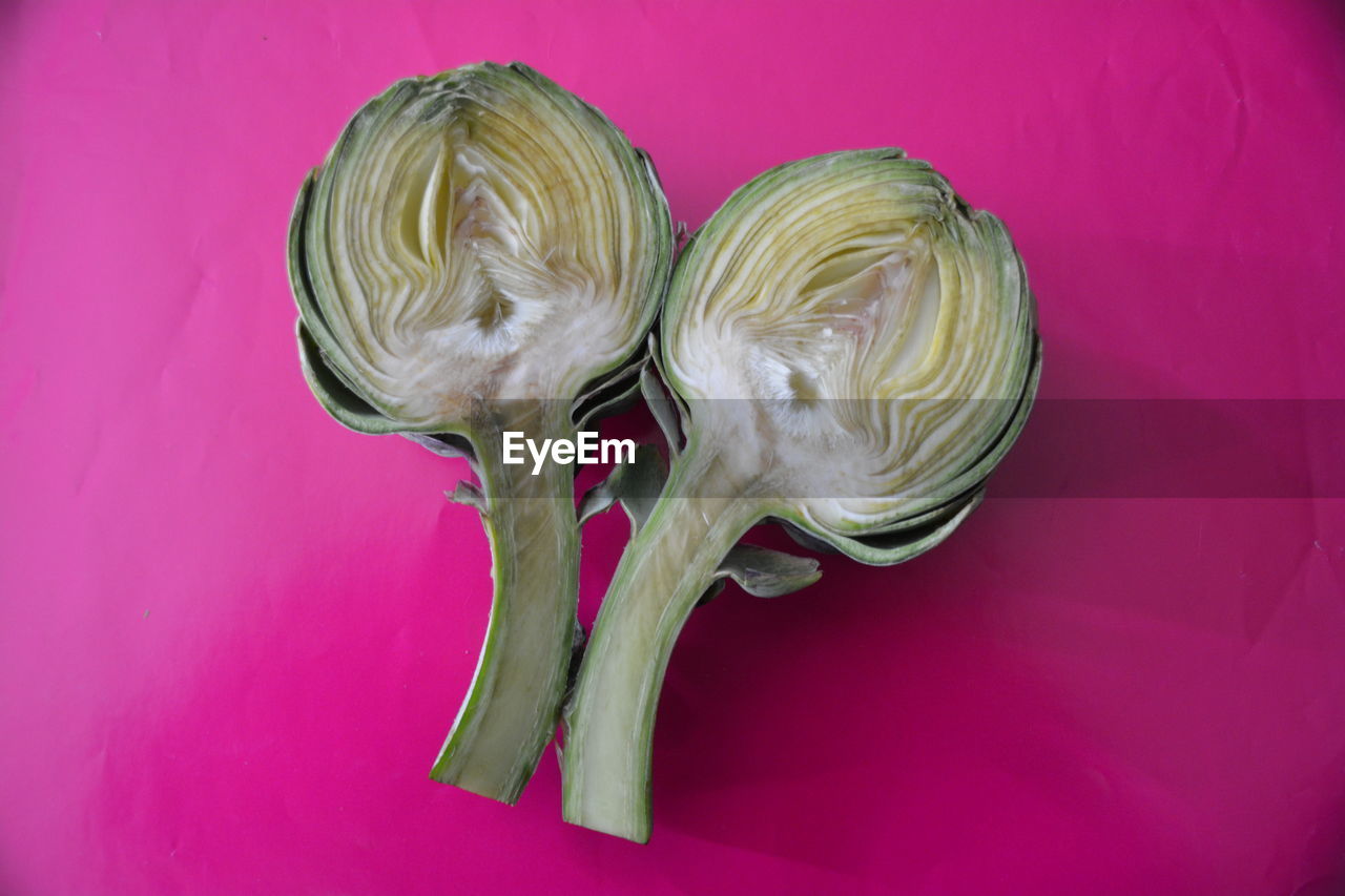 Close-up of sliced artichoke on pink background