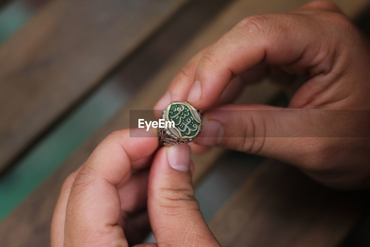 High angle view of person holding ring with text