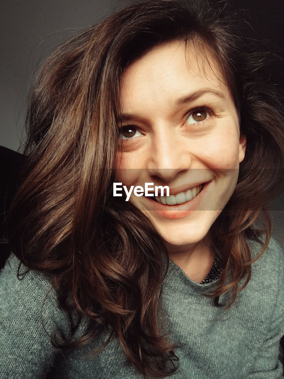 Close-up of smiling young woman with brown hair