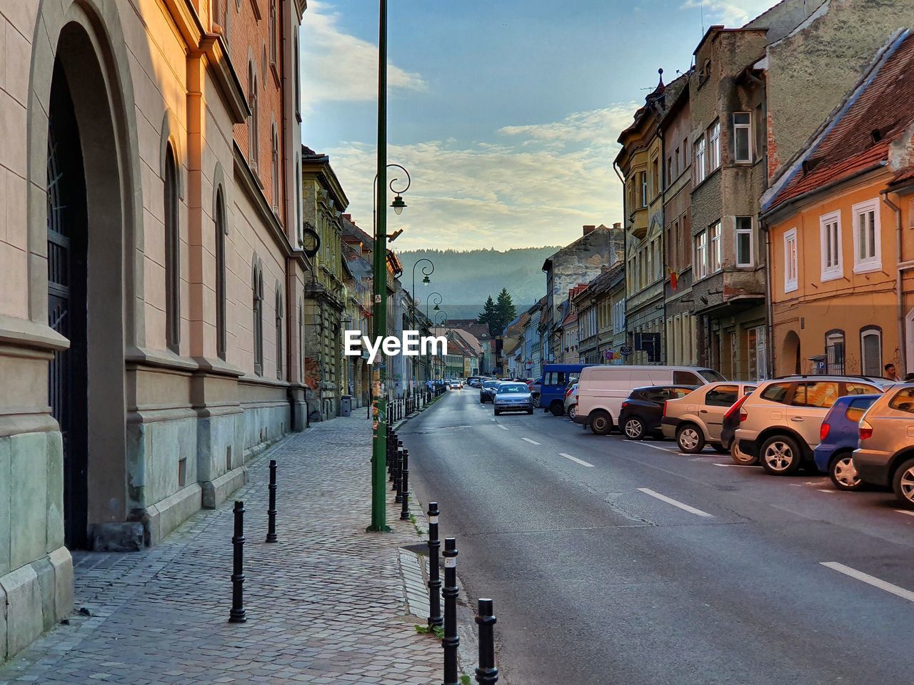 CITY STREET AMIDST BUILDINGS AGAINST SKY